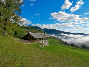 an old house on a hill in a field at Chalet Casot Pra La Funt - SMY102 by Interhome in Sampeyre