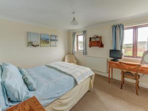 a bedroom with a bed and a desk with a computer at Holiday Home Valentines Cottage by Interhome in Braunton