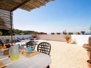 einen Tisch und Stühle auf einer Terrasse mit Meerblick in der Unterkunft Apartment Carlino by Interhome in Nerano