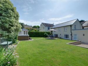 a large yard with a house and a lawn at Holiday Home Watery Lane by Interhome in Croyde