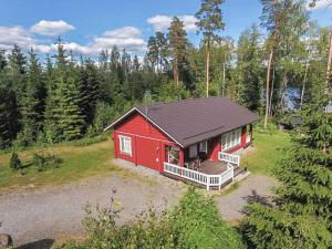 une cabane rouge au milieu d'une forêt dans l'établissement Holiday Home Kuikanranta by Interhome, à Hara