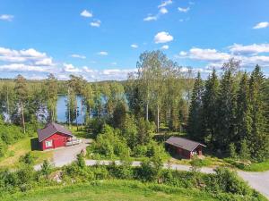 une vue aérienne de deux bâtiments rouges et d'un lac dans l'établissement Holiday Home Kuikanranta by Interhome, à Hara