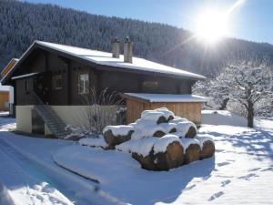 a house covered in snow with the sun behind it at Apartment Sweda by Interhome in Fieschertal