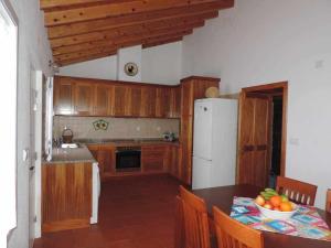 a kitchen with a table and a white refrigerator at Quinta das figueiras in Velas