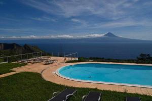a swimming pool with a view of the ocean at Quinta das figueiras in Velas