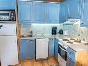 NissiにあるHoliday Home Mustikkaranta by Interhomeのキッチン(青いキャビネット、シンク、コンロ付)