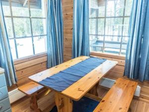 ein Holztisch in einem Raum mit Fenstern in der Unterkunft Holiday Home Mustikkaranta by Interhome in Nissi + 20 Fotos