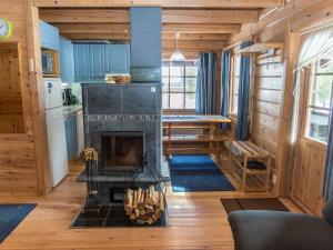 ein Wohnzimmer mit Kamin in einem winzigen Haus in der Unterkunft Holiday Home Mustikkaranta by Interhome in Nissi