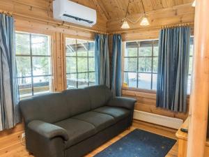 ein Wohnzimmer mit einer Couch und einigen Fenstern in der Unterkunft Holiday Home Mustikkaranta by Interhome in Nissi