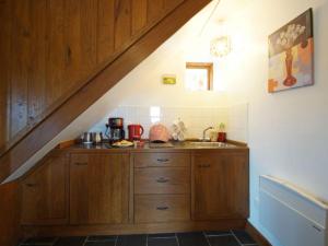 LlanbrynmairにあるHoliday Home Uwch y Foel by Interhomeのキッチン(木製キャビネット、階段の下にシンク付)
