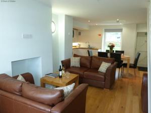 a living room with two couches and a table at Holiday Home Dwy by Interhome in Llithfaen