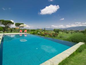uma grande piscina azul com duas cadeiras num quintal em Holiday Home Il Loto by Interhome em Cortona
