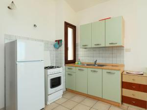 kuchnia z białymi szafkami i białą lodówką w obiekcie Apartment Limette 2 by Interhome w mieście Valledoria +20 zdjęć
