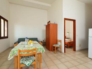 kuchnia i jadalnia ze stołem i lodówką w obiekcie Apartment Limette 2 by Interhome w mieście Valledoria