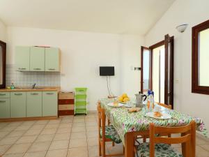 kuchnia ze stołem z krzesłami i stolikiem w obiekcie Apartment Limette 2 by Interhome w mieście Valledoria