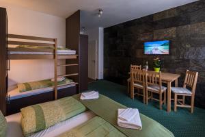 ein Schlafzimmer mit einem Etagenbett und einem Tisch sowie ein Esszimmer in der Unterkunft Babi Guesthouse - Babi Vendégház in Balatonfüred