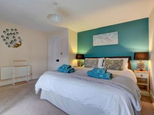 ブラントンにあるHoliday Home Cross Farm Cottage by Interhomeのベッドルーム1室(青い壁の大きな白いベッド1台付)