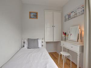 a white bedroom with a bed and a desk at Apartment Belle View by Interhome in Ilfracombe