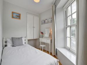 a bedroom with a bed and a desk and a window at Apartment Belle View by Interhome in Ilfracombe
