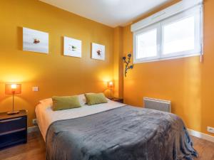 a bedroom with a large bed with yellow walls at Apartment Résidence Kerentrech-3 by Interhome in Quiberon