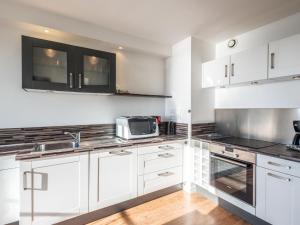 a kitchen with white cabinets and a microwave at Apartment Résidence Kerentrech-3 by Interhome in Quiberon +11 photos