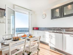 a white kitchen with a table and chairs and a window at Apartment Résidence Kerentrech-3 by Interhome in Quiberon