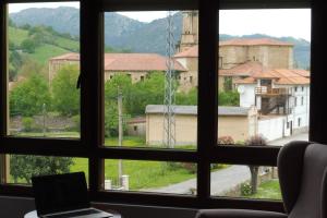 una ventana con vistas y un ordenador portátil en un escritorio en Casa Santolaya, en Santiurde de Toranzo