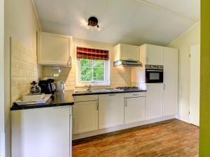 eine Küche mit weißen Schränken und einem Fenster in der Unterkunft Holiday Home Buitenplaats Gerner-3 by Interhome in Dalfsen
