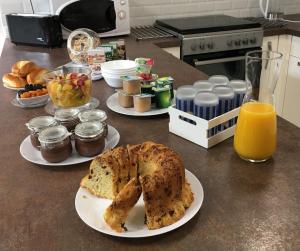 einen Tisch mit zwei Brotplatten und Orangensaft in der Unterkunft La Maison des Matignon 2 in Granville