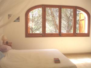 een slaapkamer met een bed en een open raam bij Beautiful detached villa close to sandy beach, shops and restaurants in Begur