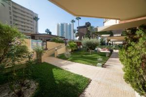einen Garten inmitten einer Stadt mit Gebäuden in der Unterkunft Moonkey - Apartamento Las Naranjas in Benidorm