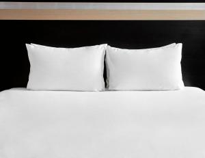 a white bed with three pillows on top of it at Holiday Inn Bristol City Centre, an IHG Hotel in Bristol
