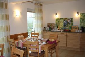 a dining room with a table and a kitchen at Weingut Goeres in Briedel