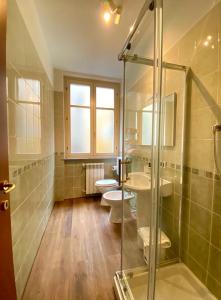 a bathroom with two toilets and a glass shower at HH Hermoso Housing SERRAVALLE in Serravalle Scrivia