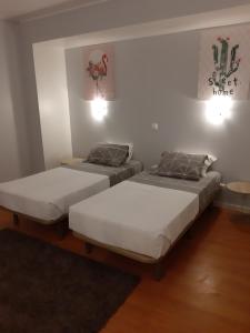 two twin beds in a room with two lamps at Apartamentos Matur Flats 2 in Machico