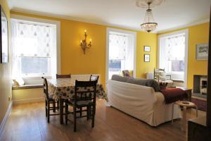 a living room with a couch and a table and chairs at 136 West Princes Street in Helensburgh