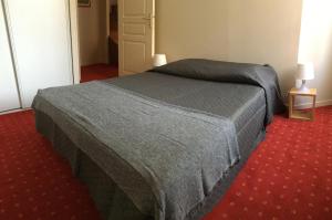 1 dormitorio con 1 cama y alfombra roja en La Maison des Matignon 2 en Granville