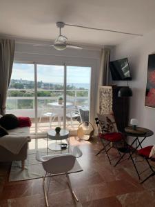 a living room with a view of a table and chairs at Vue mer exceptionnelle, El Rosario (Marbella). in Marbella