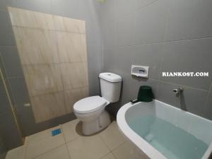 a bathroom with a toilet and a bath tub at Rian Kost - Hotel Penginapan Murah Pusat Kota Palembang in Palembang +41 photos