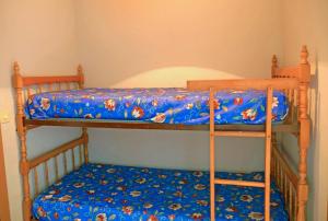 sypialnia z 2 łóżkami piętrowymi i niebieskim kocem w obiekcie Apartamentos Playa Romana Park w mieście Alcossebre