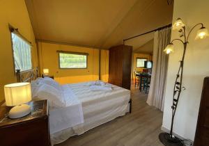 a bedroom with a bed and a table and a mirror at Glamping Tenuta San Pierino Agriturismo in Rosignano Marittimo