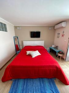 sypialnia z czerwonym łóżkiem i czerwonym kocem w obiekcie Viky House w Katanii