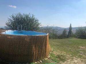 eine große Holzbadewanne in einem Hof mit einem Feld in der Unterkunft Casale Pian di Fratta in Fabro