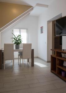 ein Esszimmer mit einem Tisch und Stühlen sowie einem TV in der Unterkunft Corte del Tintor Apartments in Venedig