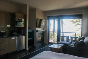 een hotelkamer met een woonkamer met een open haard bij Black Rock Oceanfront Resort in Ucluelet