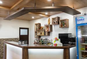 a bar in a room with alcohol bottles on the wall at Гюмюрджински Снежник in Kirkovo