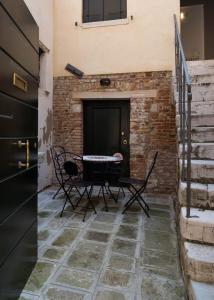 eine Terrasse mit einem Tisch und Stühlen neben einer Ziegelwand in der Unterkunft Corte del Tintor Apartments in Venedig