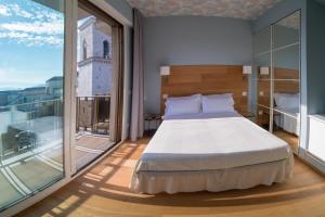 - une chambre avec un lit et une grande fenêtre dans l'établissement Gaya resort, à Bénévent