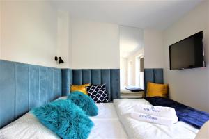 a bedroom with a bed with blue and white at Apartamenty Royal Maris 5 - pokój dwuosobowy, najlepsza lokalizacja w Ustce, blisko plaży i portu, bezpłatny parking, ścisłe centrum in Ustka