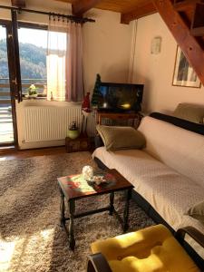 ein Wohnzimmer mit einem Sofa und einem Tisch in der Unterkunft Vikend kuća Čairović in Kopaonik